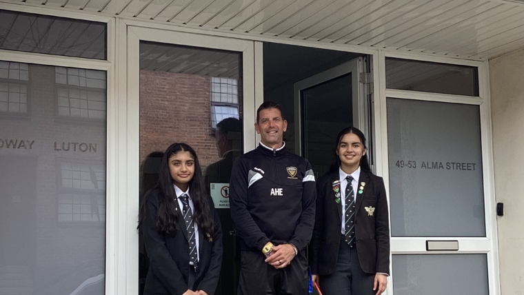 Mr Hince, Amara and Momina standing outside our front door underneath the Headway Luton logo.