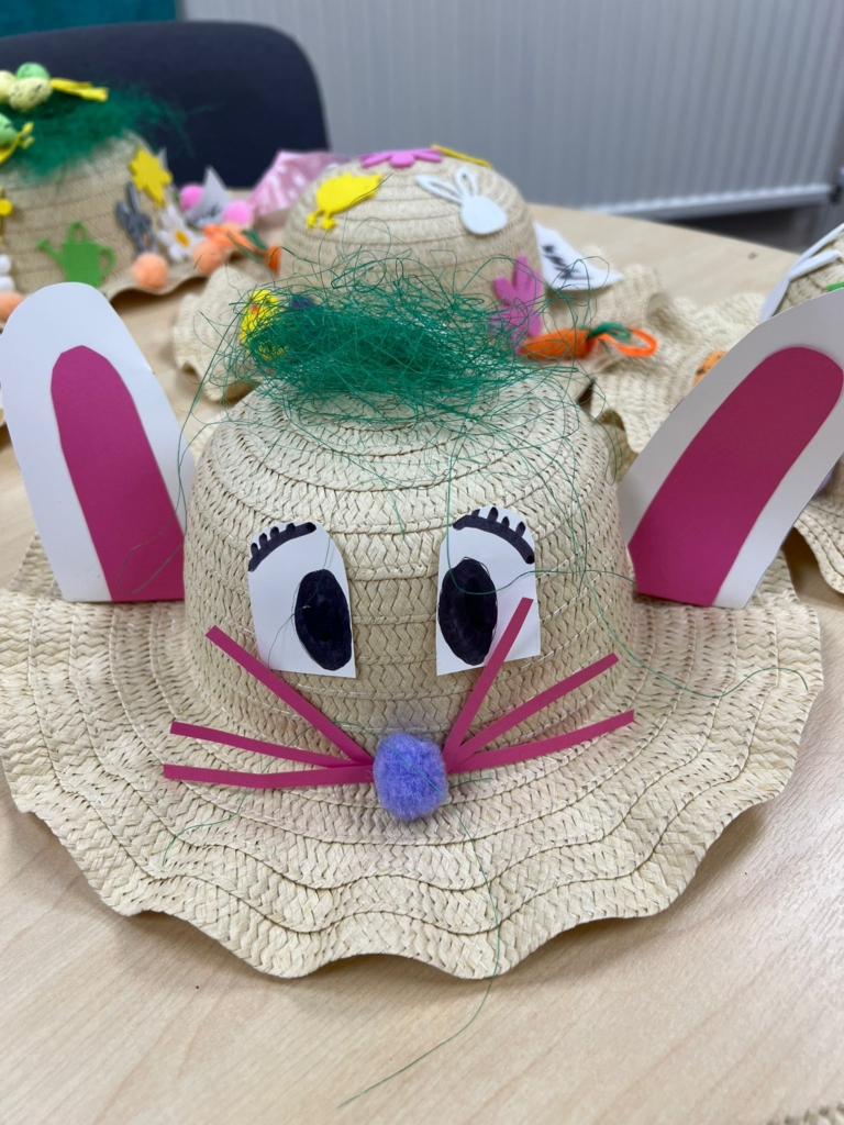 An easter bonnet with a face of a rabbit and bunny ears, although I think it actually looks like a mouse. It has a whisp of green hair on top.